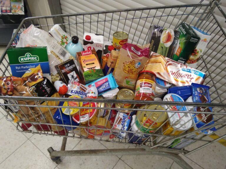 Koszyk z zakupami w sklepie podczas akcji zbiórki produktów dla osób potrzebujących.