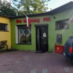 Budynek Bar Mleczny PRL z zawieszoną flagą Polski
