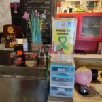 Przezroczyste pudełko na paragony akcji „Podziel się posiłkiem” na barze restauracji.