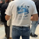 Mężczyzna w koszulce z logo fundacji rozmawia z uczestnikiem forum ewangelizacyjnego.