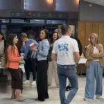 Uczestnicy forum ewangelizacyjnego rozmawiający i przechadzający się po miejscu wydarzenia.