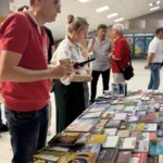 Uczestnicy forum ewangelizacyjnego wybierają książki przy stoliku.
