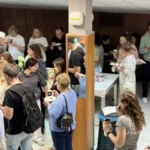 Uczestnicy warsztatów rozmawiają ze sobą i uśmiechają się podczas przerwy w wydarzeniu.