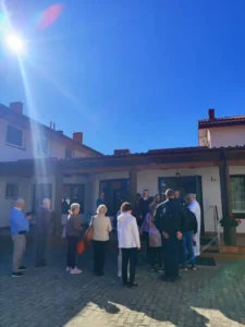 Pielgrzymi zgromadzeni przed budynkiem podczas pielgrzymki.