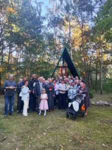 Pielgrzymi pozujący wspólnie przy krzyżu.