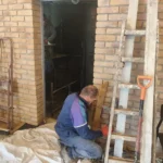 Pracownik wykonuje prace wewnętrzne w dobudowanym pomieszczeniu.